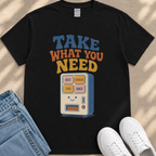 A black t-shirt with a graphic design featuring a vending machine with a smiling face and text that says "Take what you need".