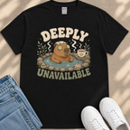 a black t-shirt with a graphic design depicting a cartoon beaver in a hot tub, surrounded by various objects such as a cup, a towel, and a pair of sunglasses. The text on the t-shirt reads "DEEPLY UNAVAILABLE".