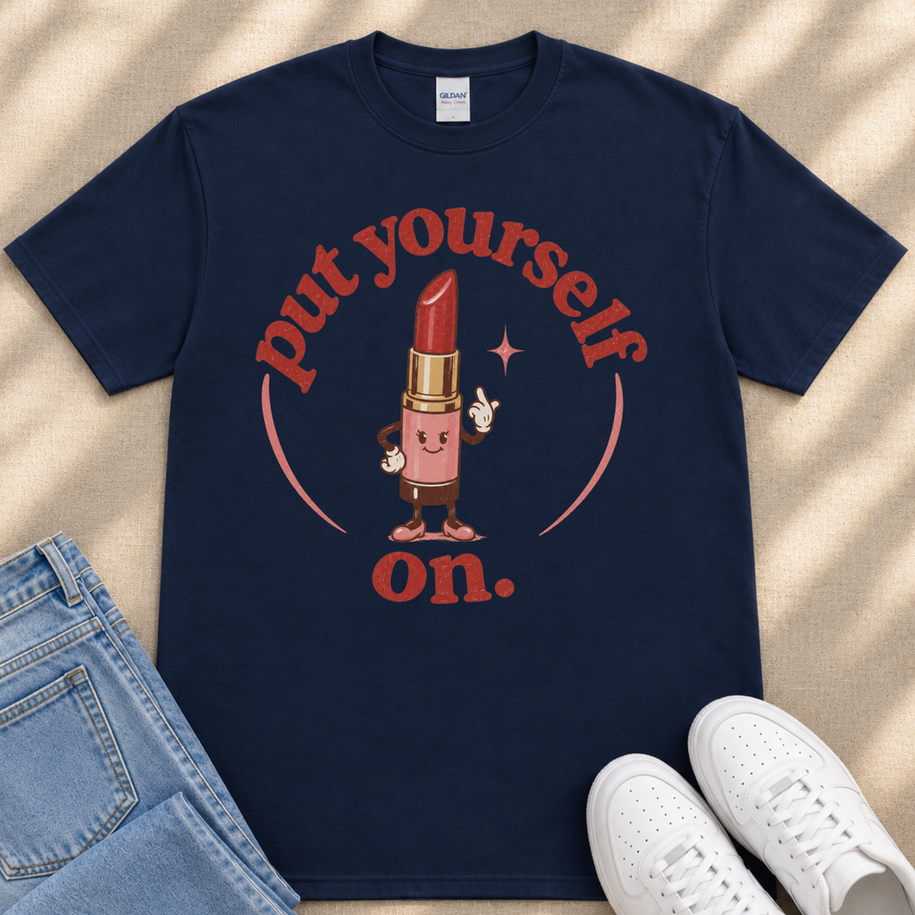 A navy blue t-shirt with a graphic design featuring a red lipstick character and the text "put yourself on."