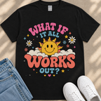 A black t-shirt with a colorful graphic design featuring a smiling sun and various decorative elements.