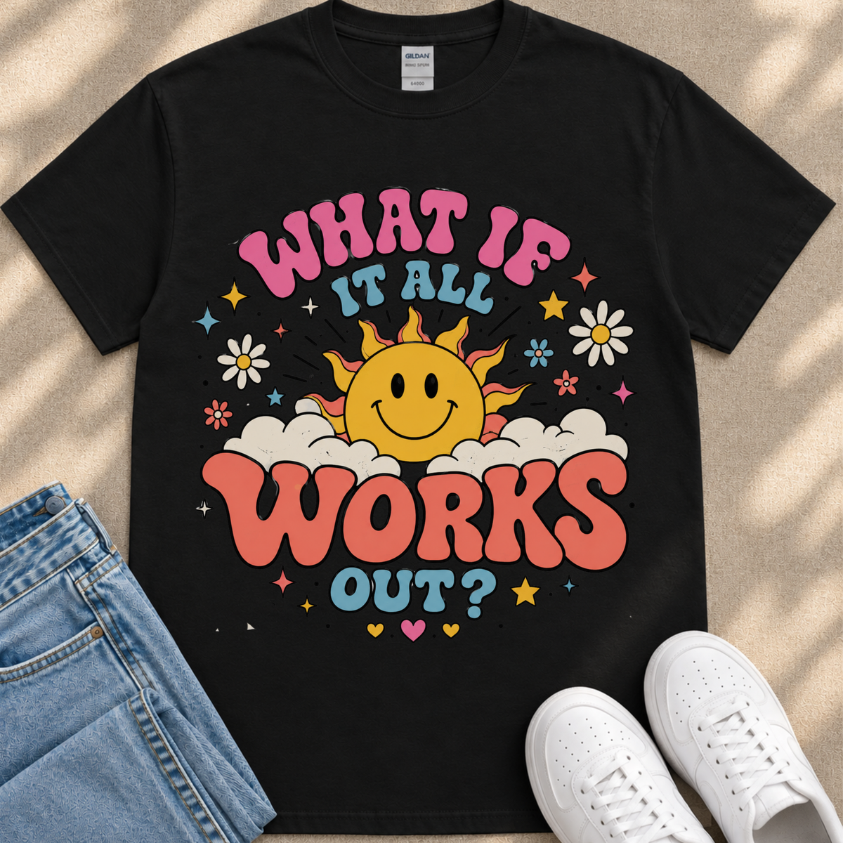 A black t-shirt with a colorful graphic design featuring a smiling sun and various decorative elements.