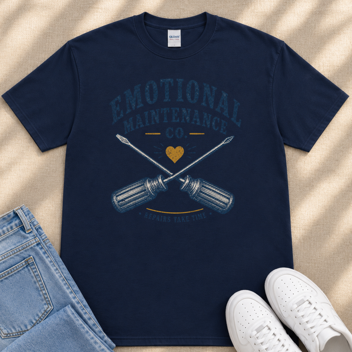 a navy blue t-shirt with a graphic design, a pair of blue jeans, and a pair of white sneakers.