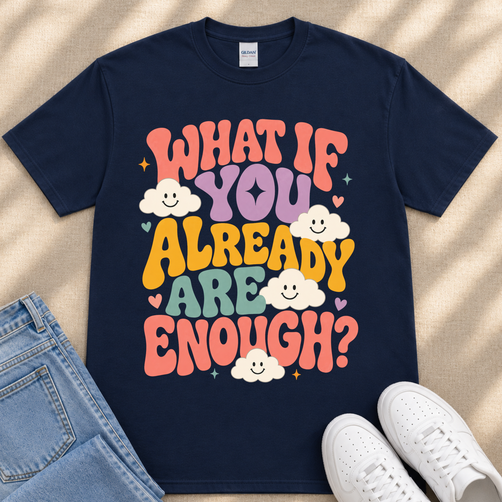 A navy blue t-shirt with a colorful graphic design featuring the text "What if you already are enough?" along with smiling clouds.