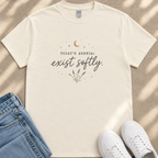 A white t-shirt with a printed design and text, along with a pair of jeans and white sneakers, laid out on a beige surface.