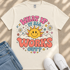 A white t-shirt with a colorful graphic design featuring a smiling sun and the text "What If It All Works Out?"