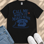 A black t-shirt with a graphic design featuring a telephone and the text "Call me when it makes sense" printed on it.