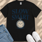 A black t-shirt with a graphic design featuring a clock and the text "SLOW IS SMART" printed on it.