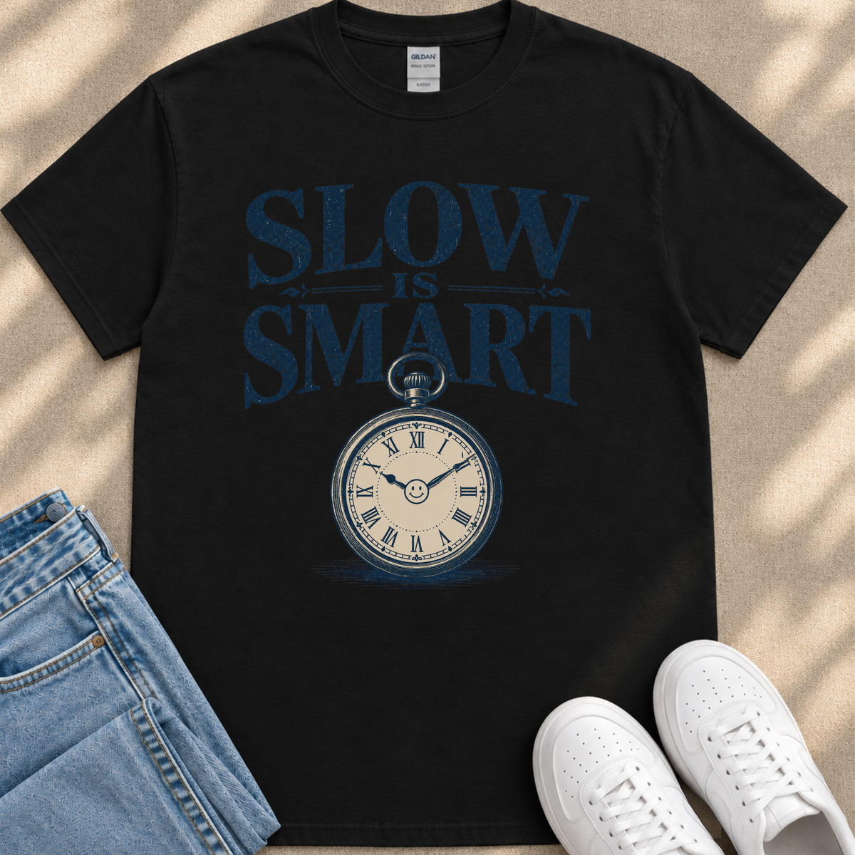 A black t-shirt with a graphic design featuring a clock and the text "SLOW IS SMART" printed on it.