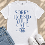 A white t-shirt with a humorous text printed on it, along with a pair of jeans and white sneakers.