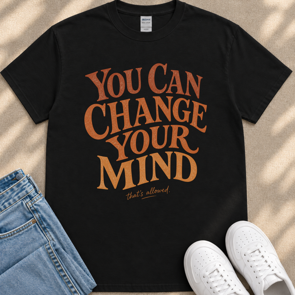 A black t-shirt with the text "You Can Change Your Mind" printed on it, along with a pair of jeans and white sneakers.
