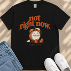 A black t-shirt with a graphic design featuring a cartoon alarm clock and the text "not right now. maybe later."