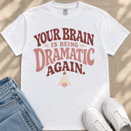 A white t-shirt with a humorous text printed on it, along with a pair of jeans and white sneakers.