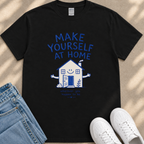 A black t-shirt with a graphic design of a house and the text "MAKE YOURSELF AT HOME" printed on it, along with a smaller text below that says "Wherever you go, good things happen to you."