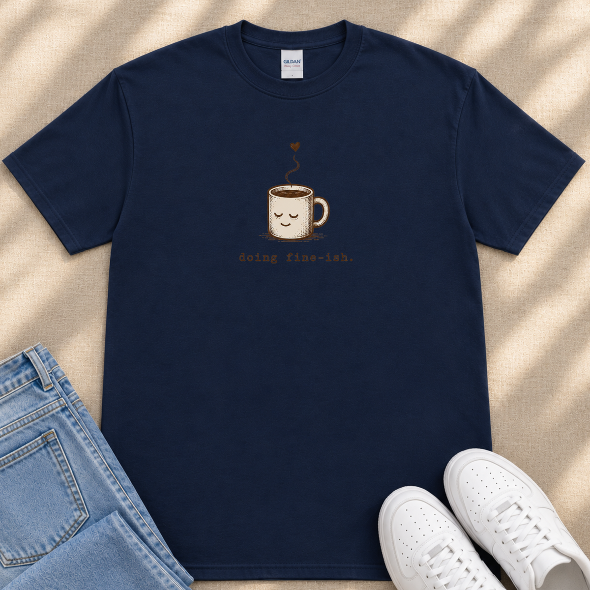 A navy blue t-shirt with a coffee mug graphic and the text " Going flu-eh." printed on it, along with a pair of jeans and white sneakers.