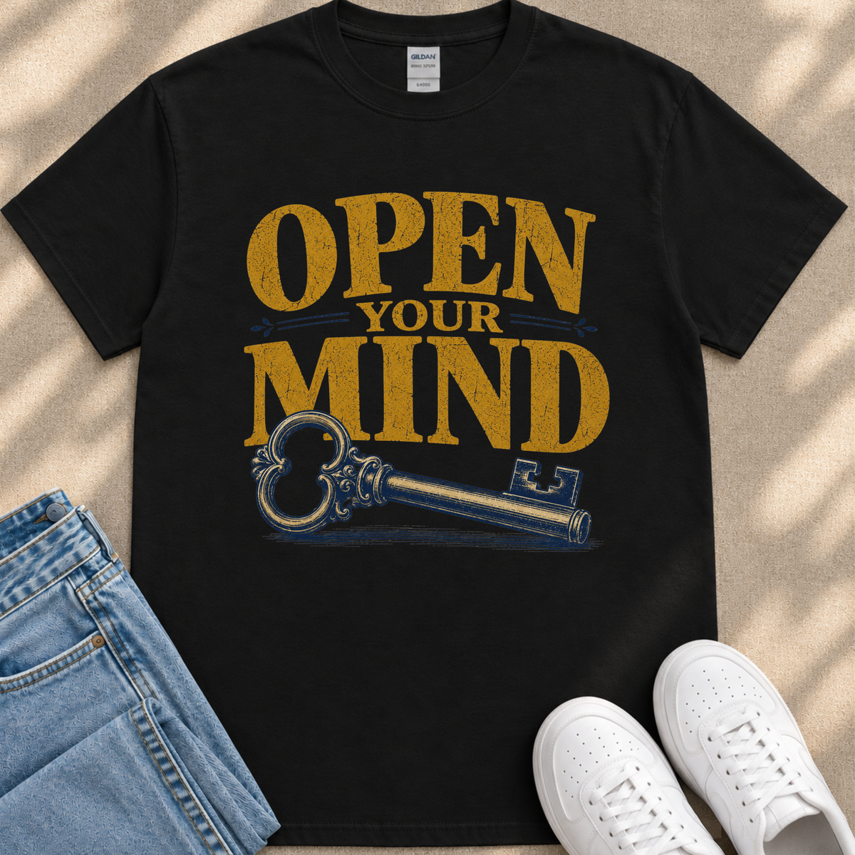 a black t-shirt with a graphic design that says "OPEN YOUR MIND" and a key, along with a pair of jeans and white sneakers.