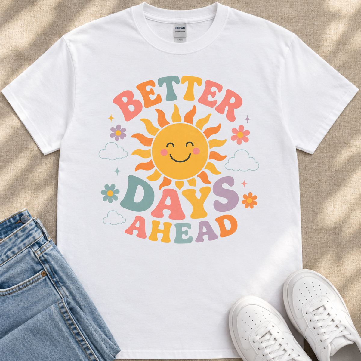 A white t-shirt with a colorful graphic design featuring a smiling sun and the text "Better Days Ahead" printed on it.