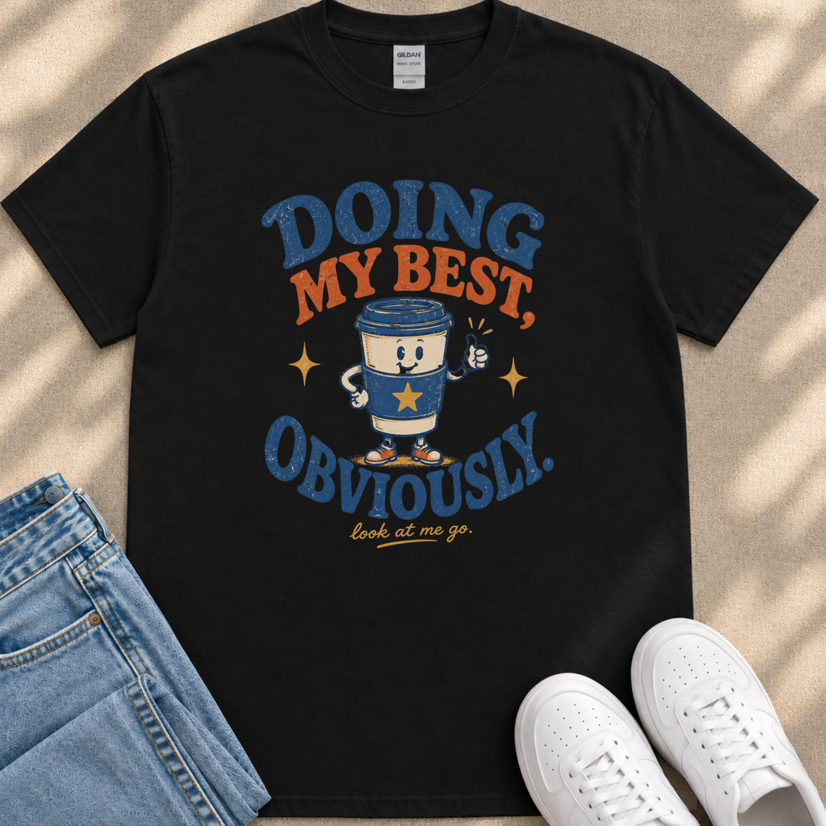 a black t-shirt with a graphic design that includes a coffee cup character and text.