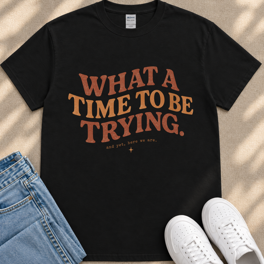 A black t-shirt with a motivational quote printed on it, along with a pair of jeans and white sneakers.