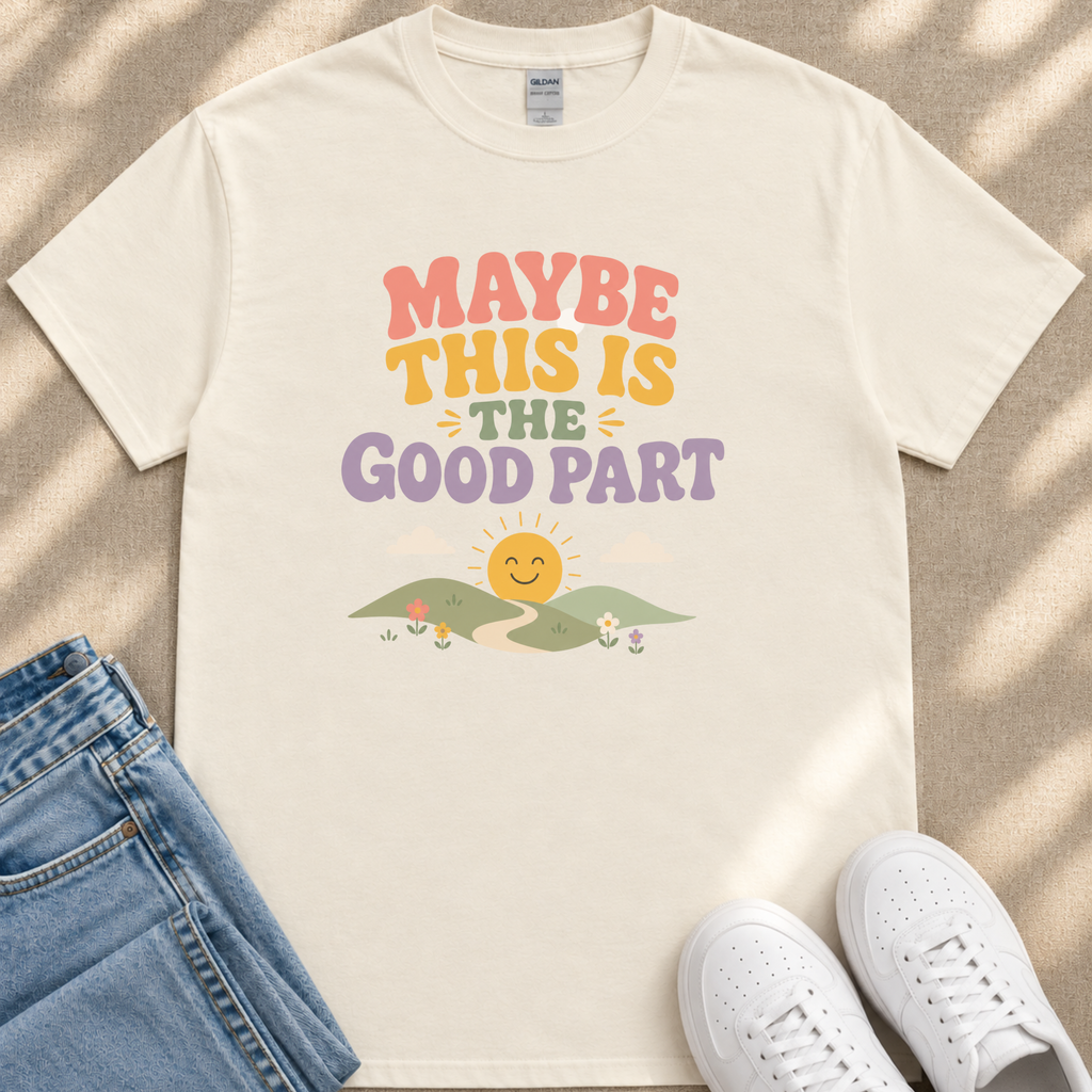 A white t-shirt with a colorful graphic design and text, along with a pair of jeans and white sneakers, all laid out on a surface.
