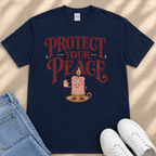 A navy blue t-shirt with a graphic design featuring a candle and the text "PROTECT YOUR PEACE" printed on it.