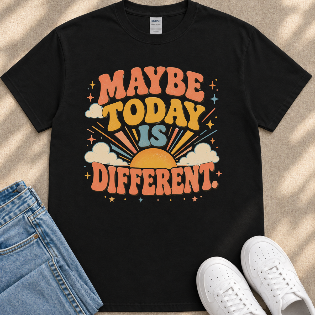 A black t-shirt with a colorful graphic design that says "MAYBE TODAY IS DIFFERENT" along with a sun and clouds design.