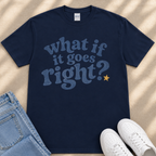 A navy blue t-shirt with the text "What if it goes right?" printed on it, along with a yellow star. The t-shirt is placed next to a pair of blue jeans and white sneakers.