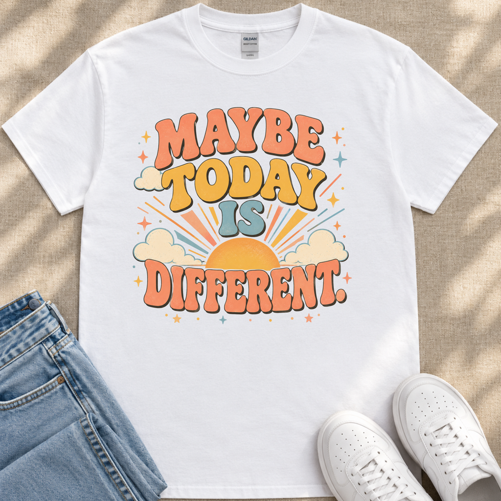 A white t-shirt with a colorful graphic design that says "MAYBE TODAY IS DIFFERENT" along with a sun and clouds design.