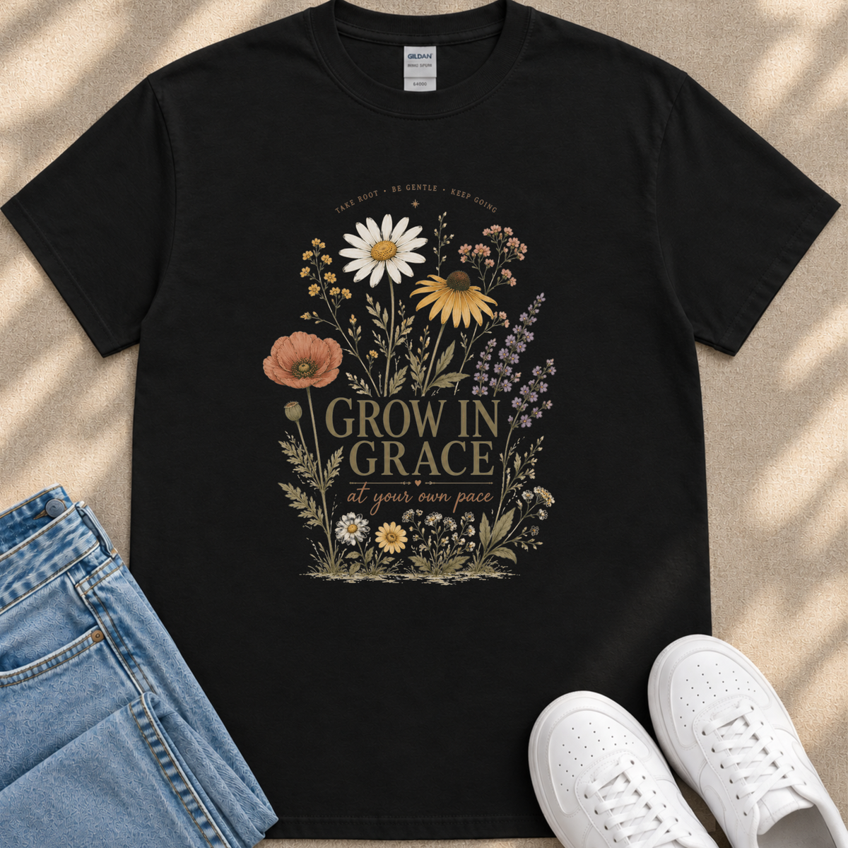a black t-shirt with a floral design and text, along with a pair of jeans and white sneakers.